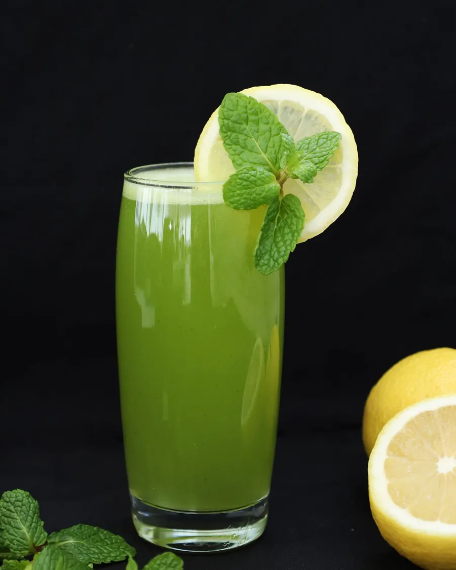 A tall glass of blended lemon and mint with a lemon wheel