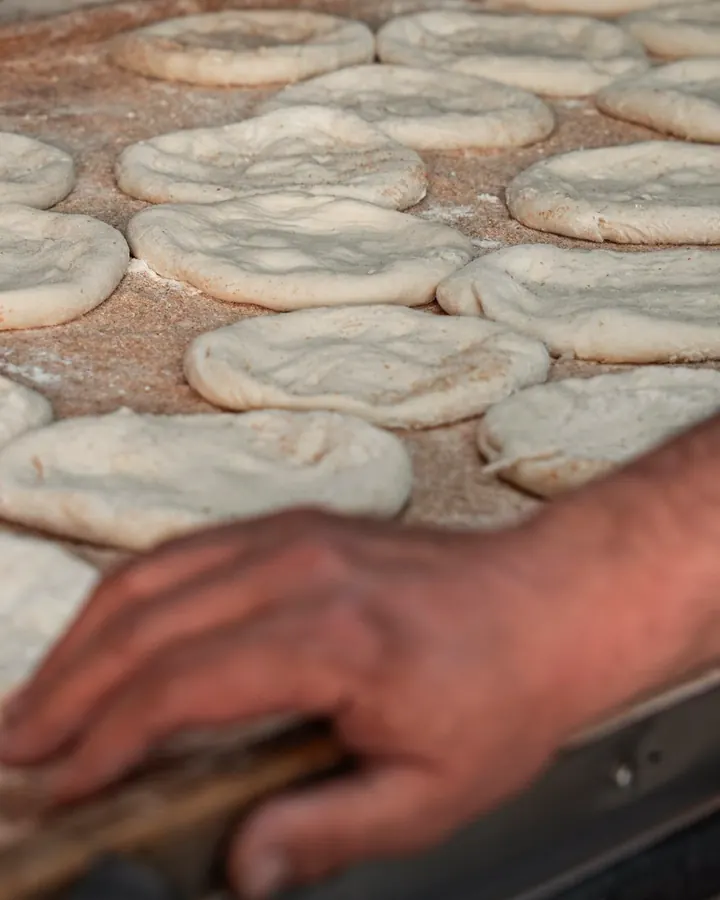 Rounds of dough resting on a floured board before they go into the oven